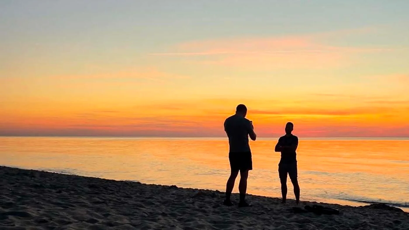Norbert Karolak z przyjacielem na plaży o zachodzie słońca
