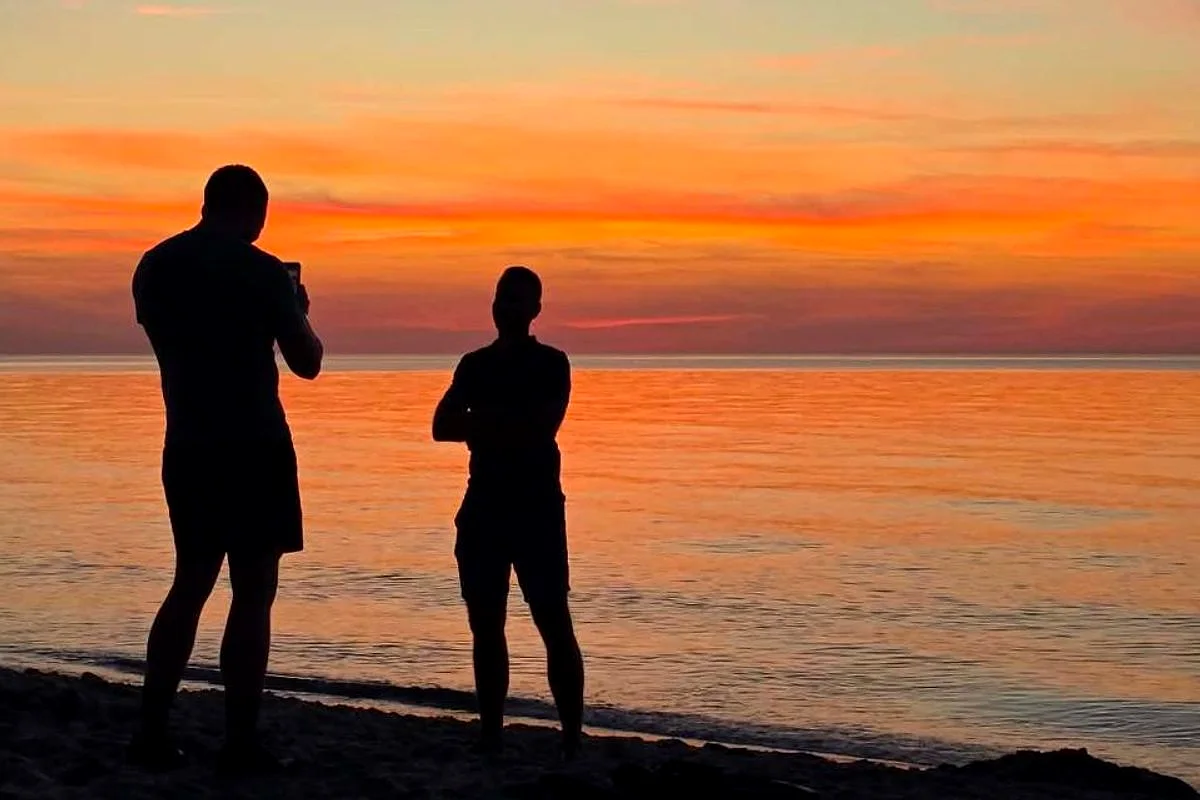 Norbert Karolak z przyjacielem na plaży o zachodzie słońca
